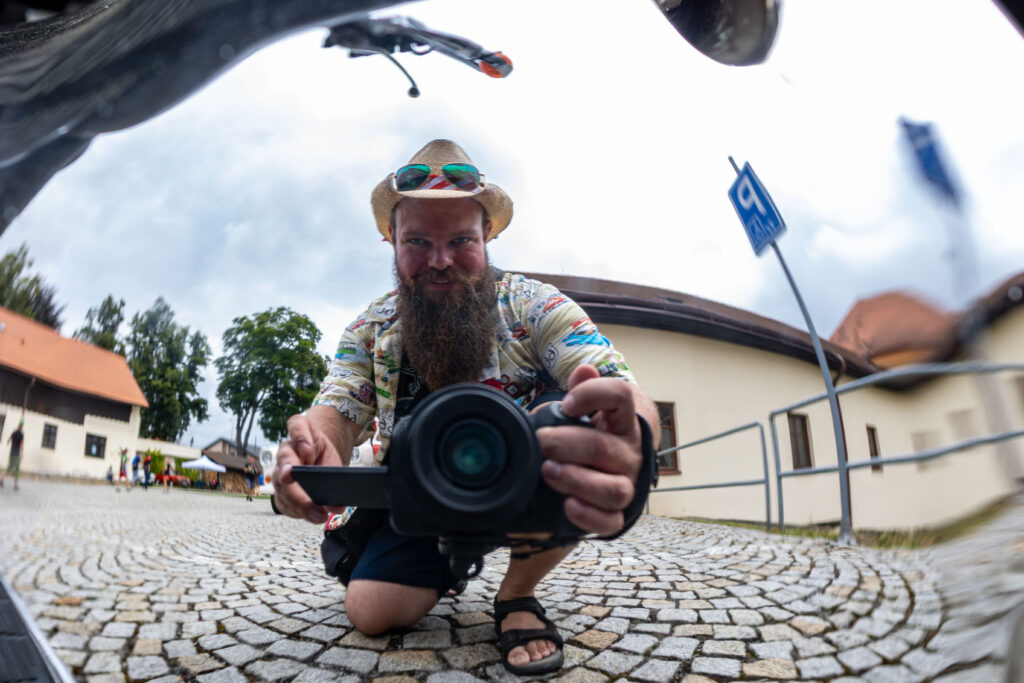 Vladimír Kotýnek fotografuje svůj odraz v naleštěném chromu motorky na dlážděném nádvoří.